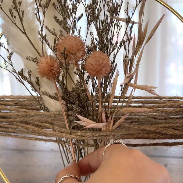 threading dried flowers through the twine