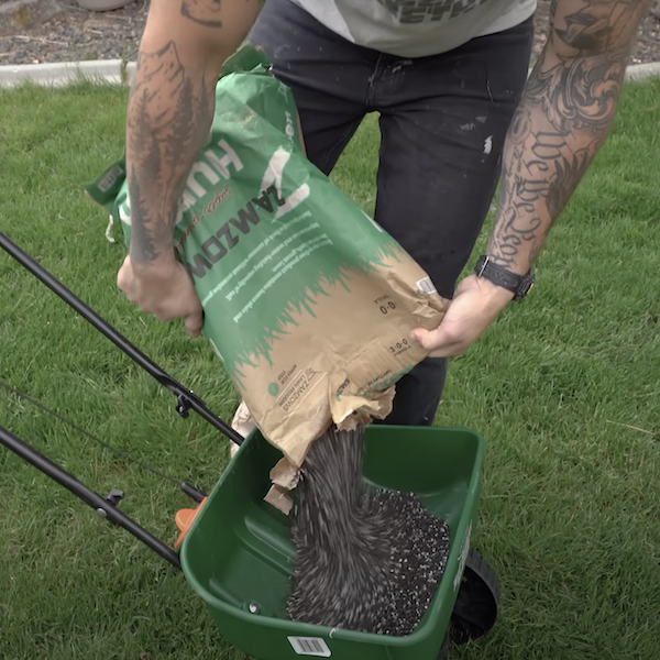 adding fertilizer to grass