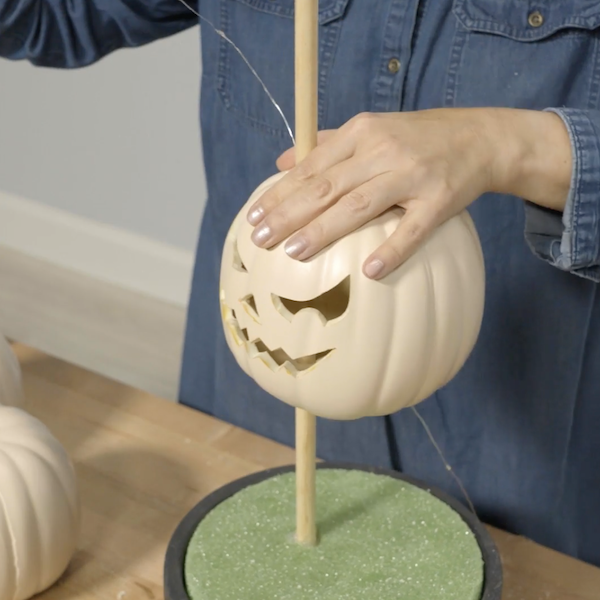 Placing the pumpkin onto the dowel. 