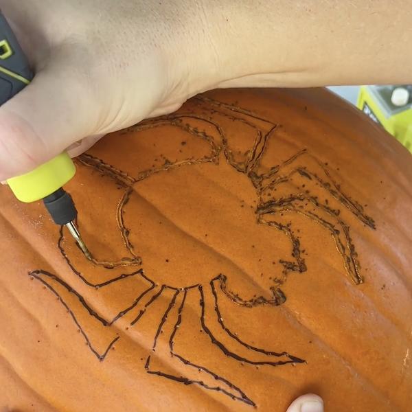 Carving the design into the pumpkin
