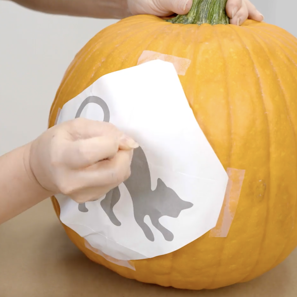 Placing the stencil on the pumpkin