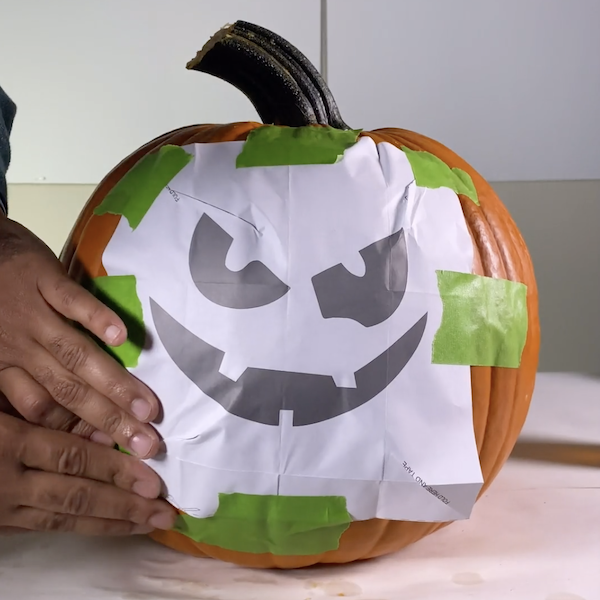 attaching stencil to pumpkin