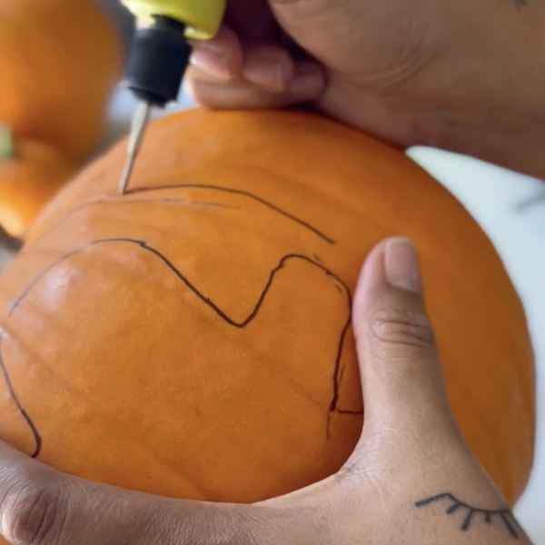 Carving design into pumpkin
