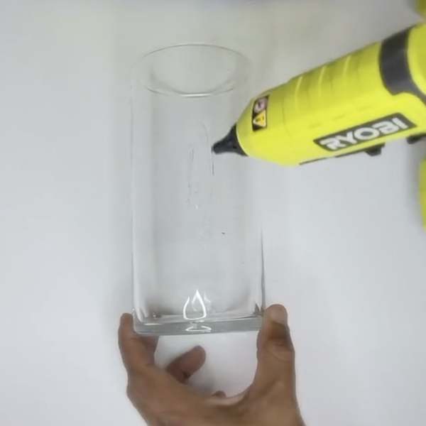 applying glue to glass vase